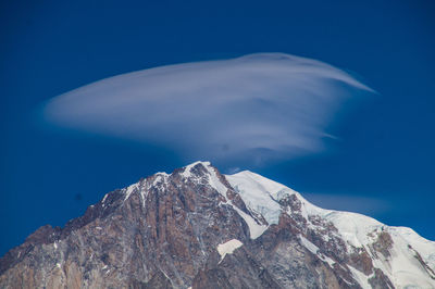 Scenic view of snowcapped mountains against blue sky