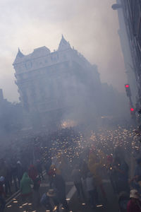 Group of people in city against sky