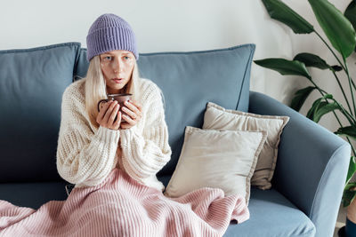 Portrait of woman sitting on sofa at home