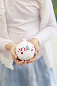 Midsection of woman holding bauble