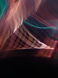 Digital composite image of light trails over black background