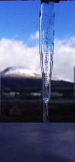 Close-up of water drop against sky