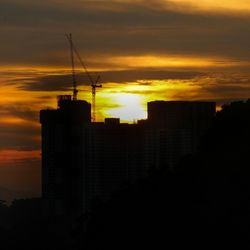 Silhouette buildings against sky during sunset