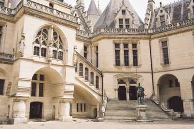 Statues against old building in city