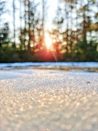 Close-up of snow against sky during sunset