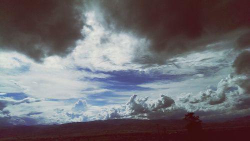 Scenic view of mountains against cloudy sky