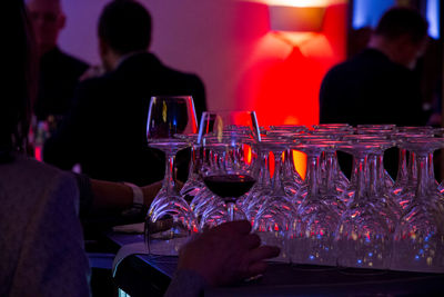 Cropped image if woman holding wineglass on table