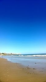 Scenic view of beach against clear blue sky