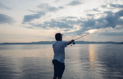 Silhouette of man fishing in sea