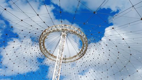Low angle view of ferris wheel against blue sky