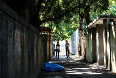 People on footpath amidst houses