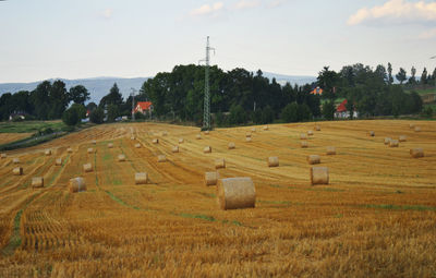 Hay bales on field against sky