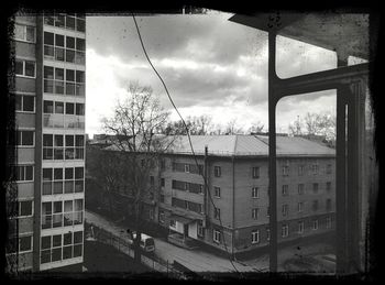 Buildings in city against cloudy sky