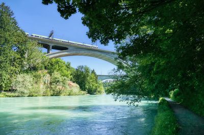 Arch bridge over river against sky