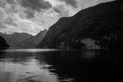 Scenic view of lake by mountains against sky