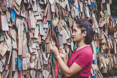 Woman looking at wooden prayer blocks in market