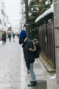 Woman standing on sidewalk in city