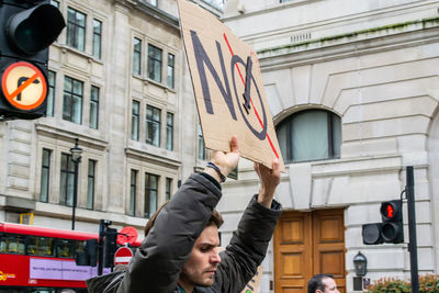 Low angle view of man standing on street against building