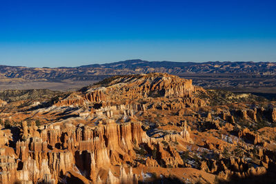 Aerial view of landscape and mountains against clear blue sky