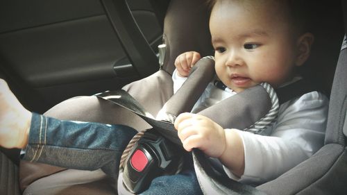 Close-up of cute baby boy sitting in car