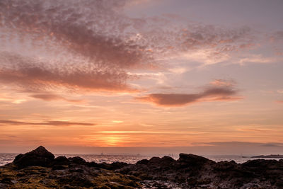 Scenic view of dramatic sky over silhouette landscape