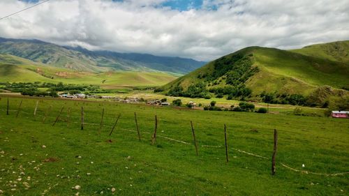 Scenic view of green landscape against sky