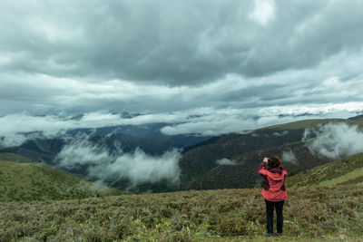 Full length of woman standing on field against sky