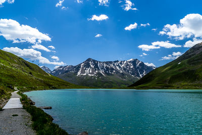 Scenic view of lake and mountains against blue sky