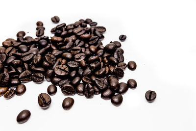 High angle view of coffee beans against white background