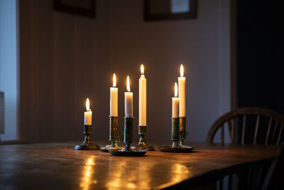 Lit candles on wooden table