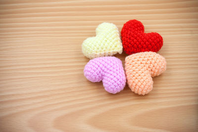 High angle view of multi colored woolen heart shapes on wooden table