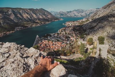 Midsection of man holding river by mountains against sky