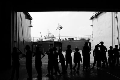 Group of silhouette people standing against sky