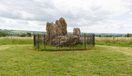 Neolithic stones on field against sky