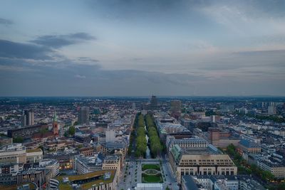 High angle view of city buildings against cloudy sky