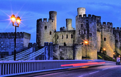 Light trails on road against buildings at night