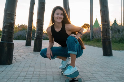 Portrait of smiling young woman on footpath