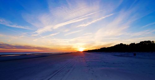 Scenic view of snow field against sky during sunset