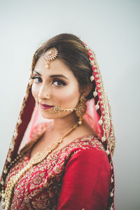 Portrait of beautiful young woman against gray background