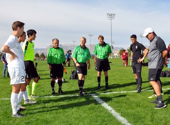 People standing on soccer field against sky