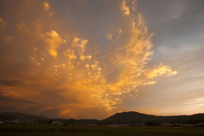 Scenic view of dramatic sky over silhouette landscape