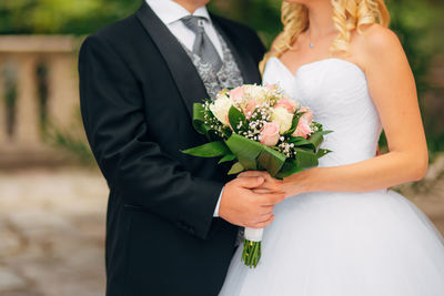 Midsection of woman holding flower bouquet