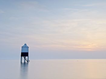 Rear view of lighthouse by sea against sky