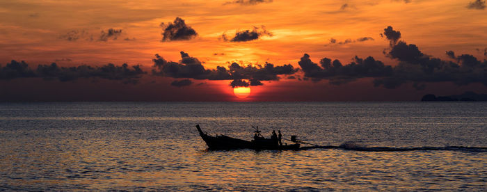 Boat sailing in sea at sunset