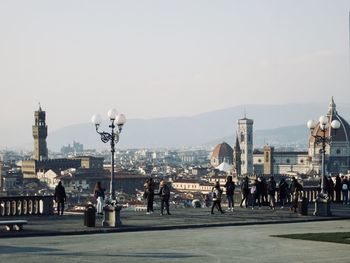 Group of people in city against clear sky