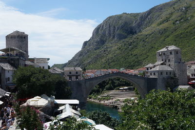 Arch bridge over river against cloudy sky