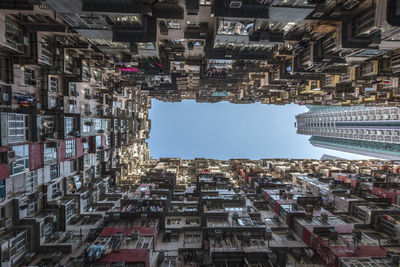 Directly below shot of residential buildings against blue sky