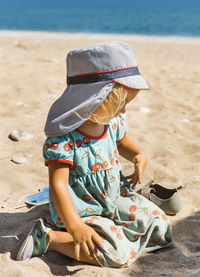 Midsection of child sitting on beach