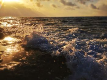 Close-up of sea against sky at sunset