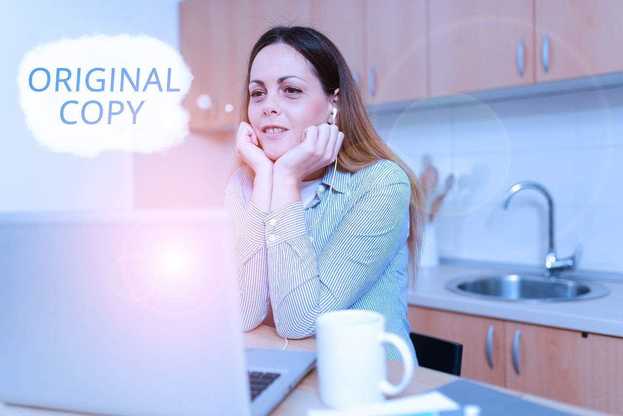 PORTRAIT OF WOMAN USING MOBILE PHONE IN OFFICE